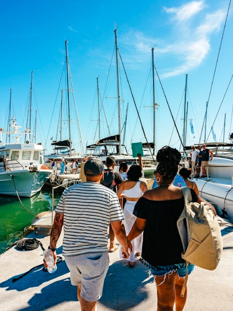 Guests boarding a catamaran for a classic cruise at a marina.