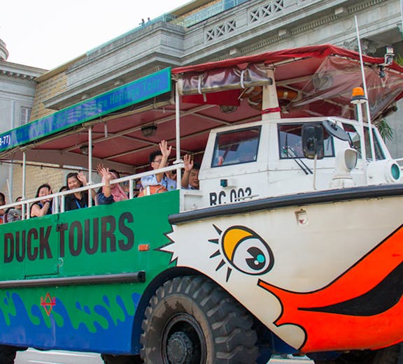 Duck tours vehicle with passengers in Singapore, offering hop-on hop-off tickets.