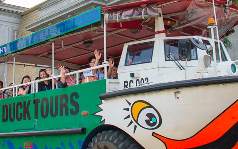 Duck tours vehicle with passengers in Singapore, offering hop-on hop-off tickets.