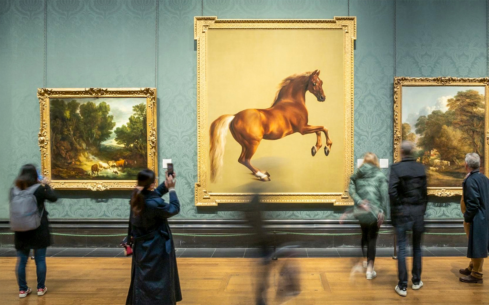 Visitors viewing paintings at the National Gallery, including a prominent horse artwork.