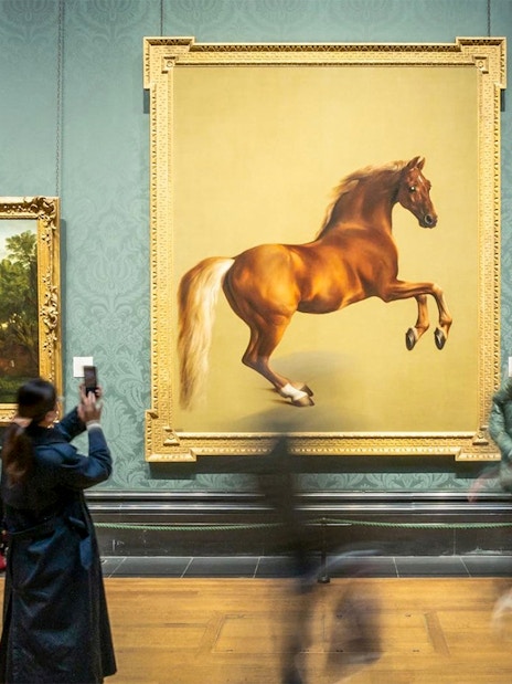 Visitors viewing paintings at the National Gallery, including a prominent horse artwork.