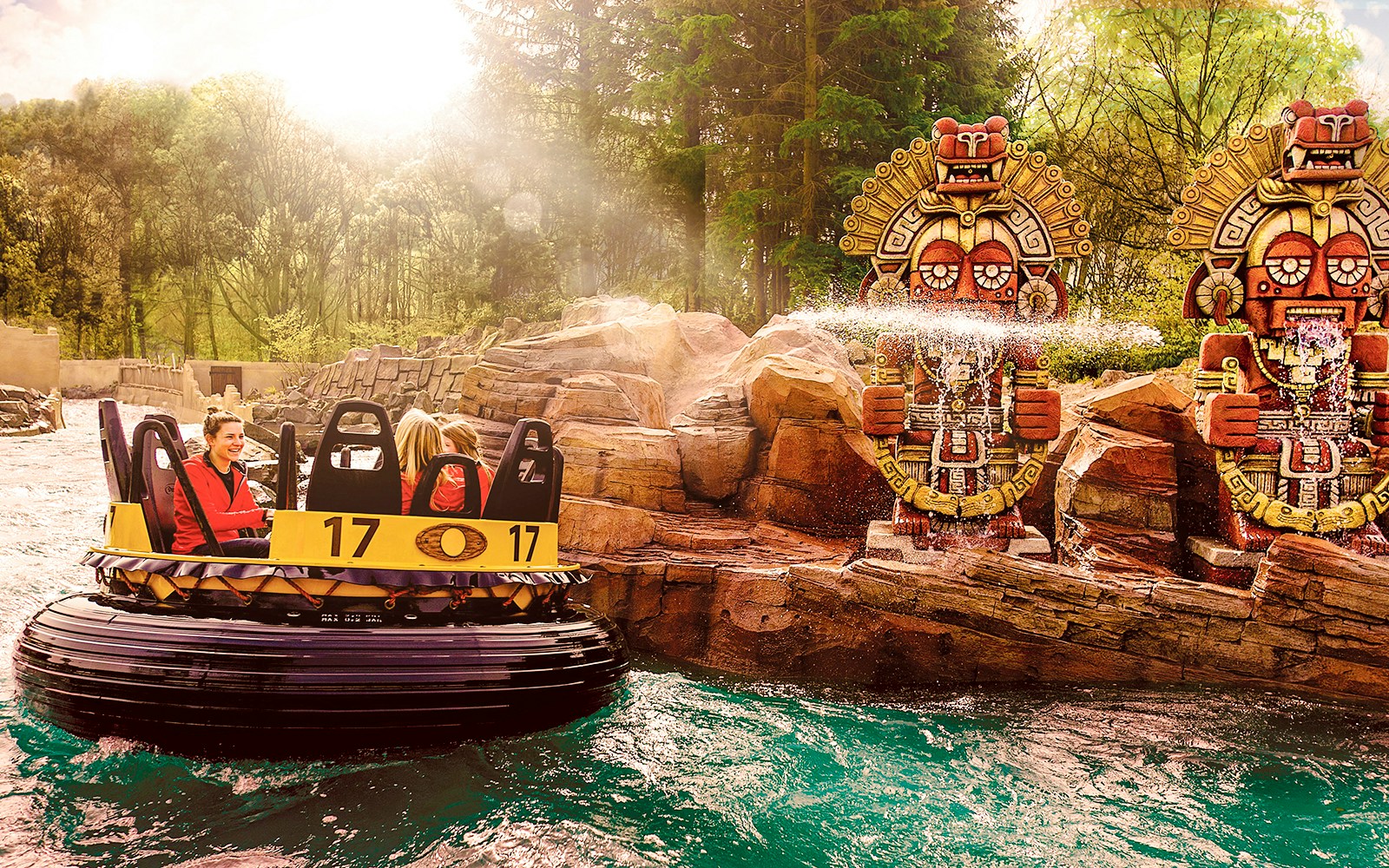 Raft ride passing by water-spraying statues at Efteling Theme Park.