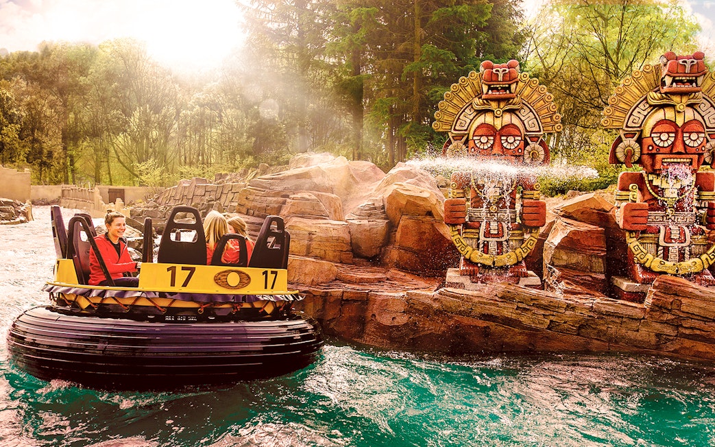 Raft ride passing by water-spraying statues at Efteling Theme Park.