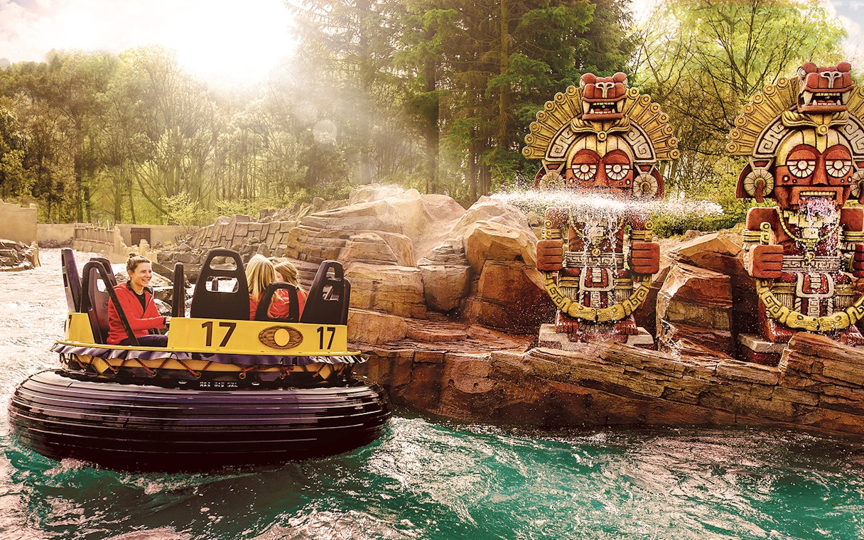 Raft ride passing by water-spraying statues at Efteling Theme Park.