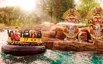 Raft ride passing by water-spraying statues at Efteling Theme Park.
