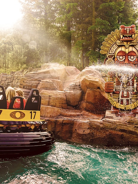 Raft ride passing by water-spraying statues at Efteling Theme Park.