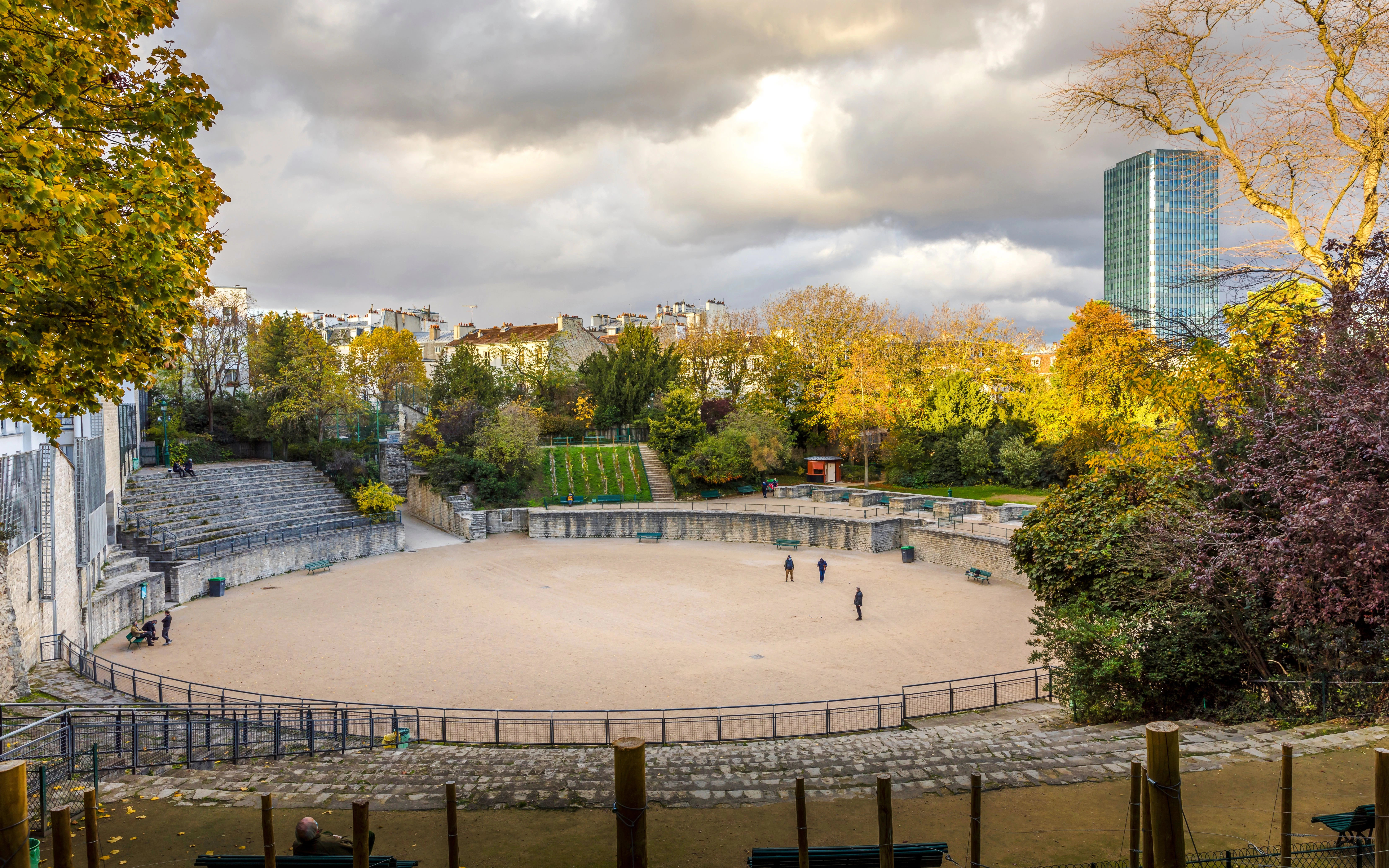 Arenes de Luteces ancient Roman amphitheater in Paris with autumn trees and cityscape.