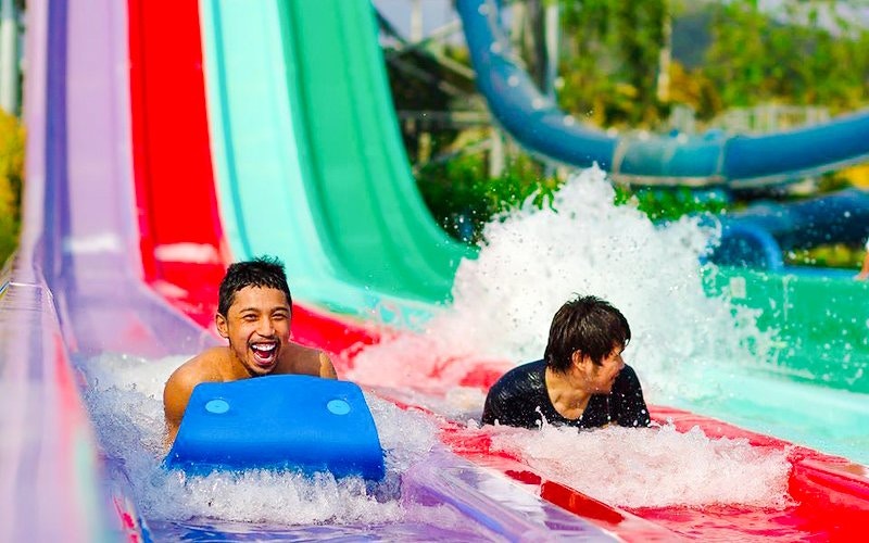 Water park visitors enjoying colorful slides.