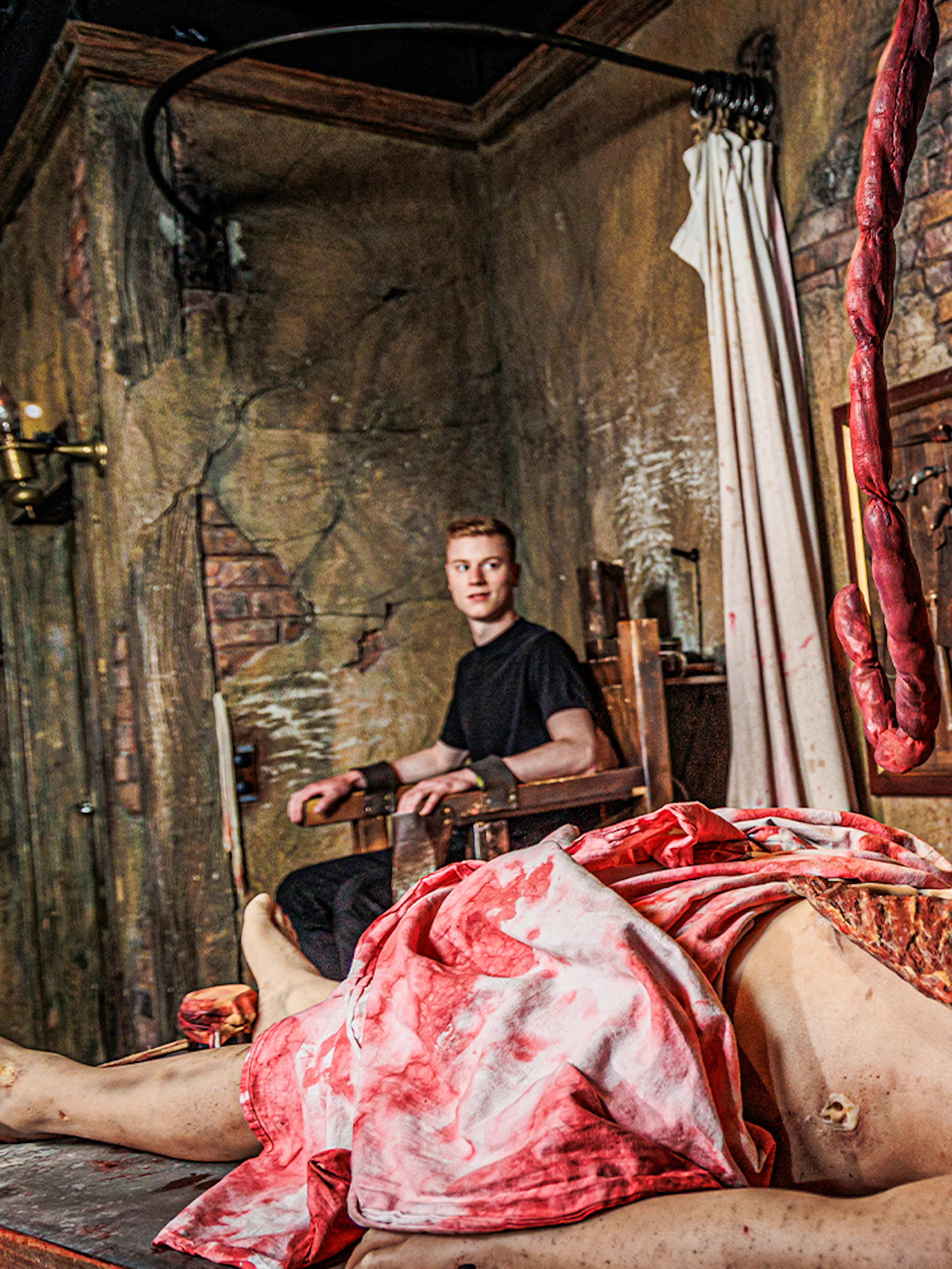 Actor in period costume performing surgery scene at London Dungeon.