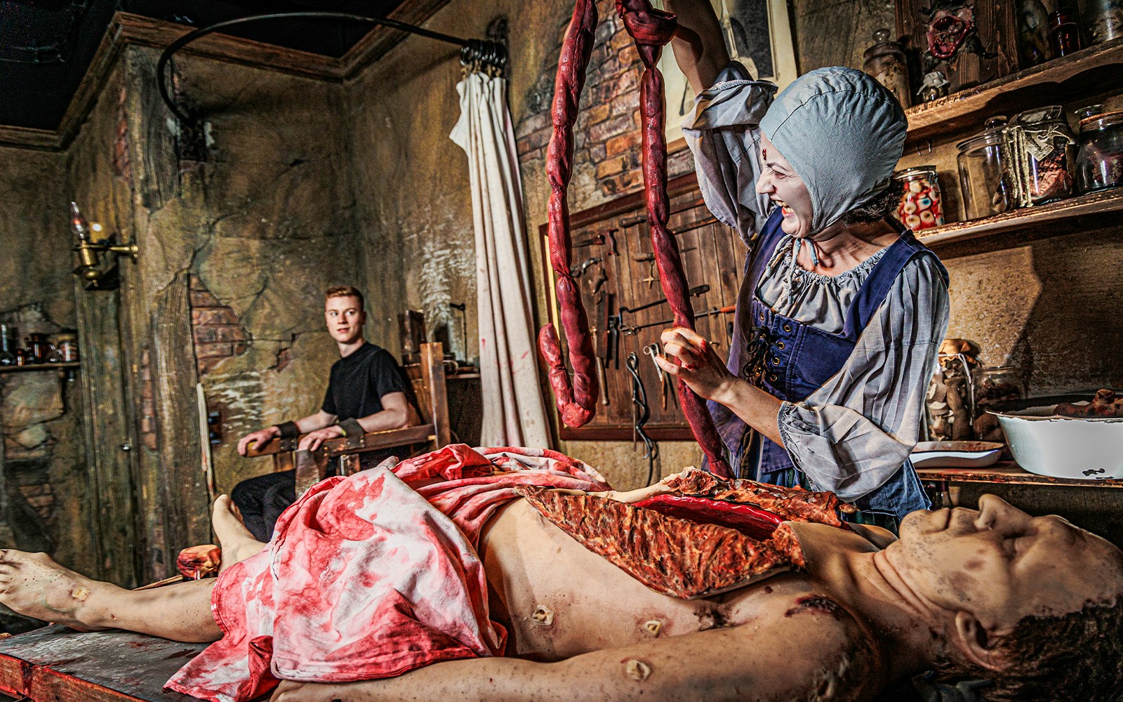 Actor in period costume performing surgery scene at London Dungeon.