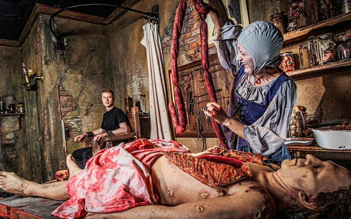 Actor in period costume performing surgery scene at London Dungeon.