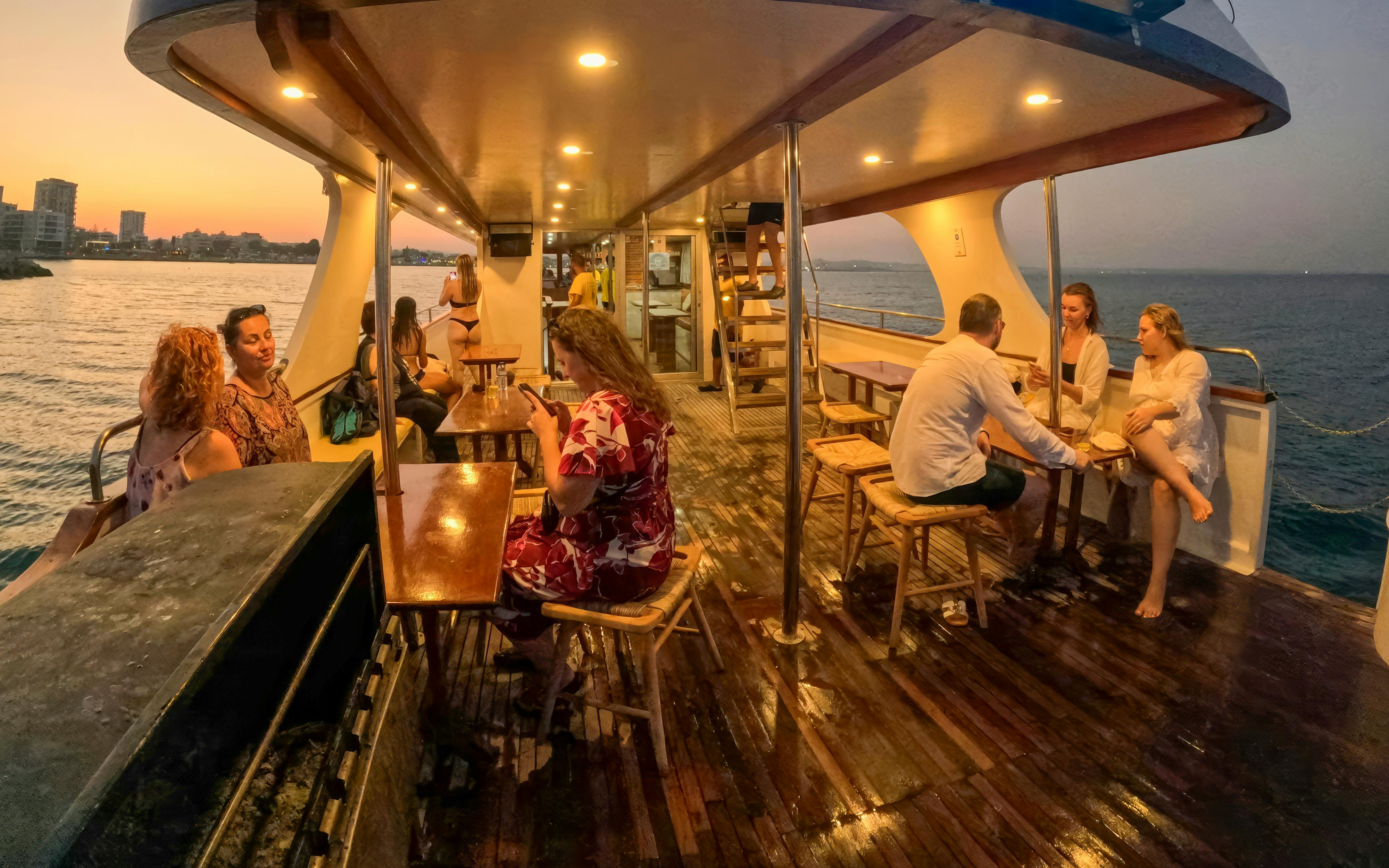 Cruise passengers relaxing on deck during sunset on Blue Lagoon tour from Larnaca.