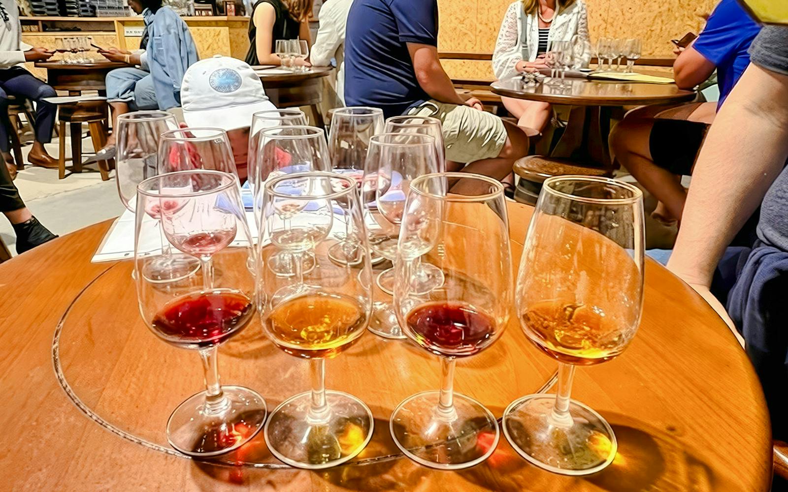 Guests seated at tables enjoying a wine tasting experience with glasses of red and white wine.