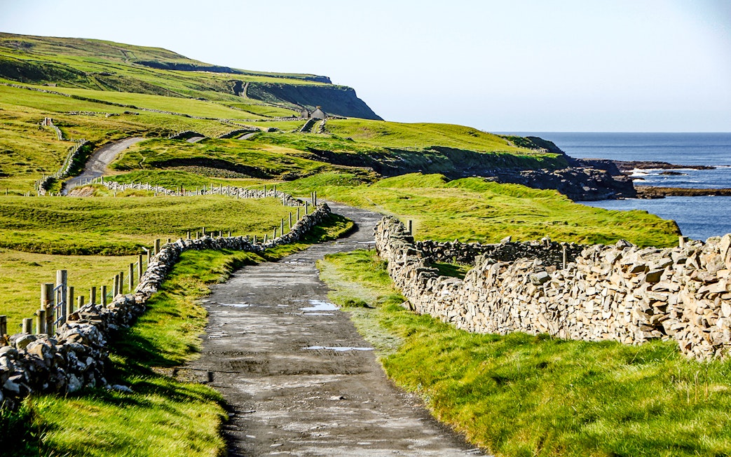 Footpath from Doolin to Cliffs of Moher with stone walls and ocean view.