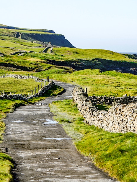Footpath from Doolin to Cliffs of Moher with stone walls and ocean view.