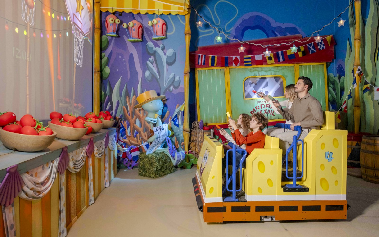 Guests on a carnival ride at Nickelodeon Play Tersane Istanbul, aiming at targets.