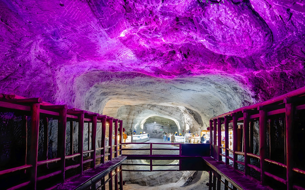 Salt Cathedral of Zipaquirá illuminated cave with water reflection.