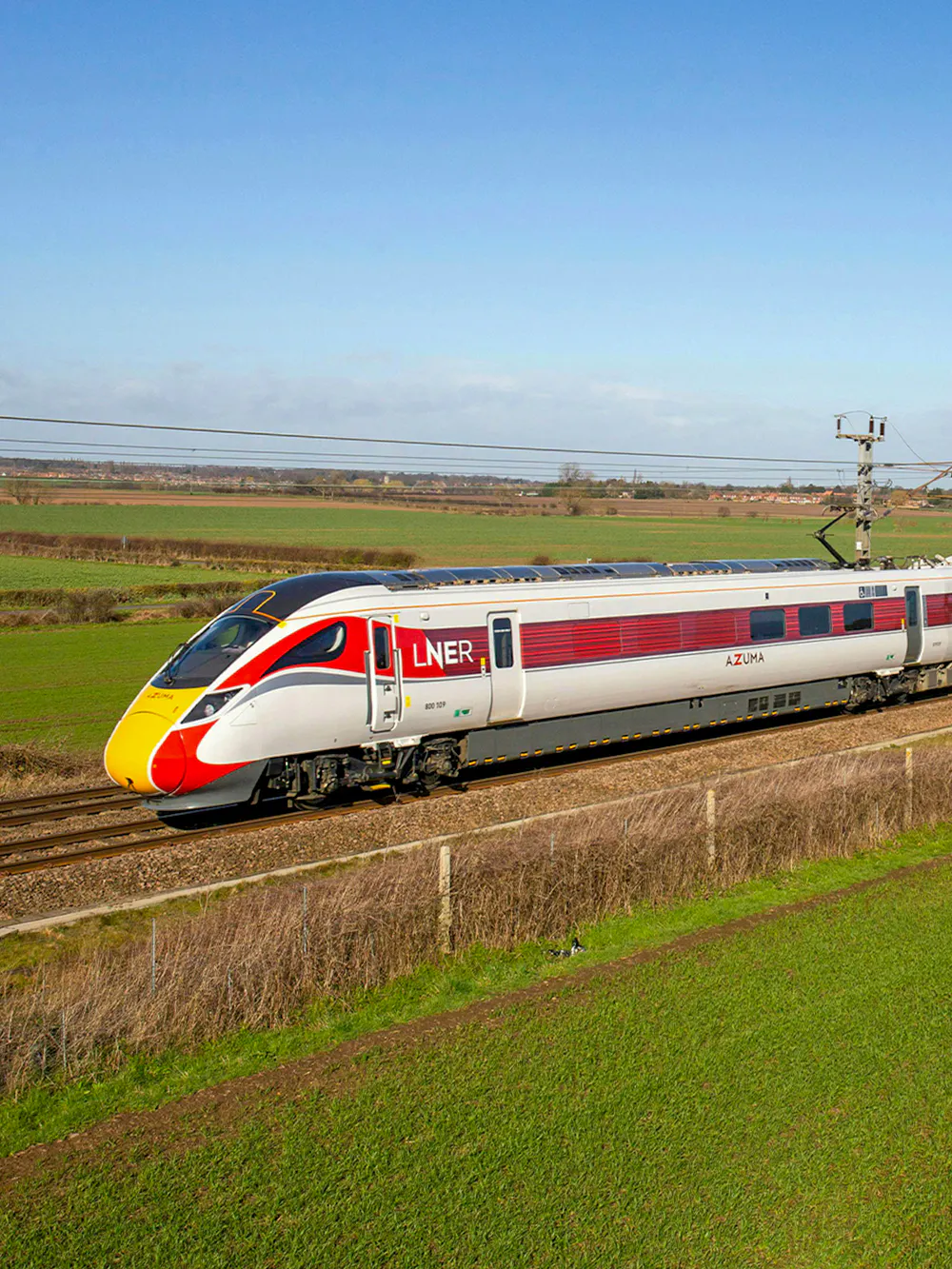 Train on BritRail network in rural England, showcasing LNER Azuma service.