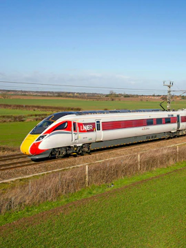 Train on BritRail network in rural England, showcasing LNER Azuma service.