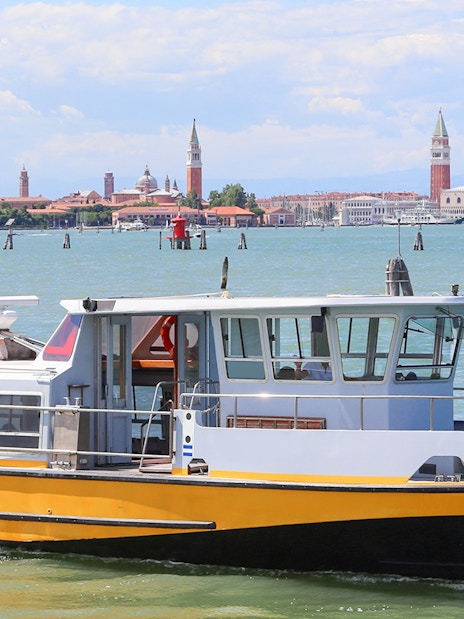 Ferry boat on the water with Venice skyline in the background.