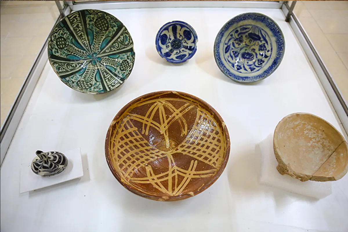 Ceramic bowls and artifacts displayed in Amman museum exhibit.