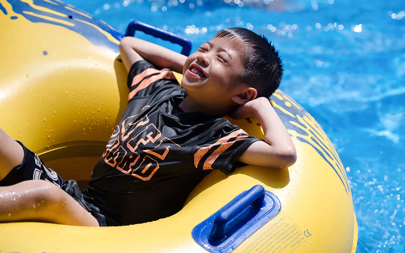 Kid relaxing on a yellow float at Wet World Water Park Shah Alam.