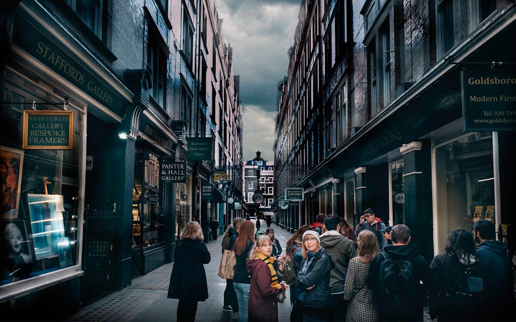 Visitors exploring Harry Potter film locations in London alleyway.