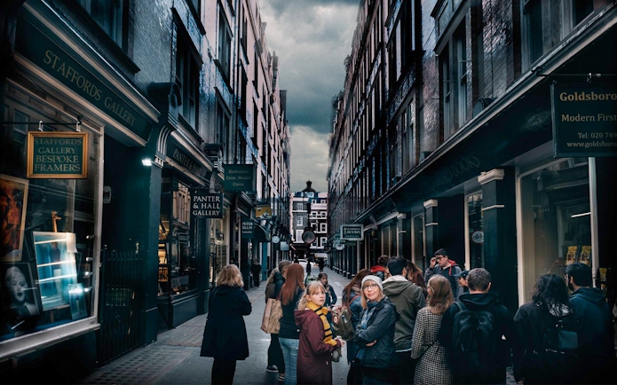 Visitors exploring Harry Potter film locations in London alleyway.