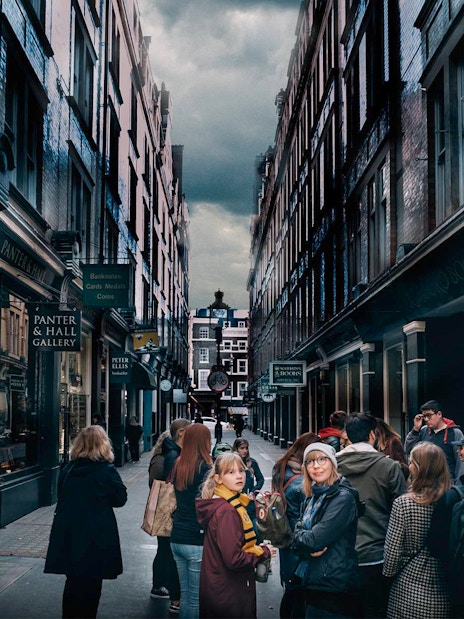 Visitors exploring Harry Potter film locations in London alleyway.