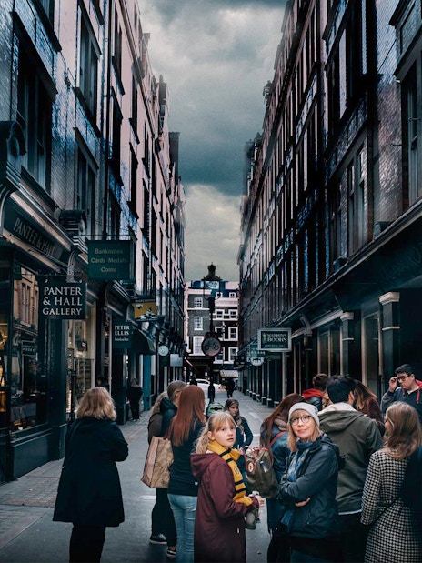 Visitors exploring Harry Potter film locations in London alleyway.