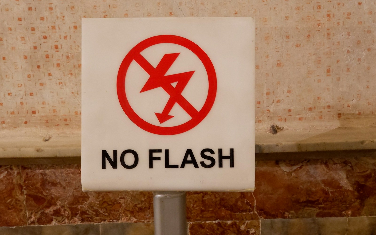 No flash photography sign at tourist facility.