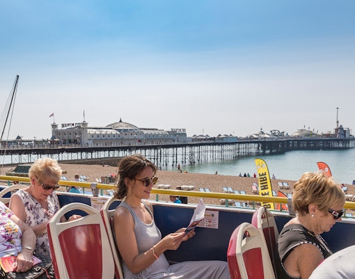 Tourists enjoying the City Sightseeing 1-Day Hop-On Hop-Off Bus Tour in New Orleans, passing by iconic landmarks