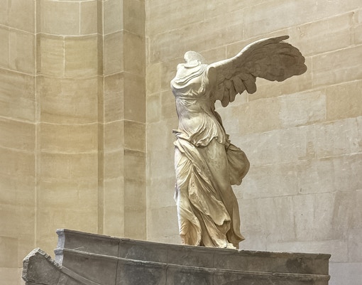 Winged Victory of Samothrace statue inside the Louvre Museum in Paris, a unique highlight of the museum tour