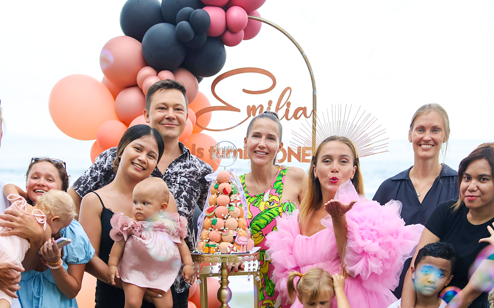 Group celebrating at Flamingo Beach Club with balloons and a decorative cake.