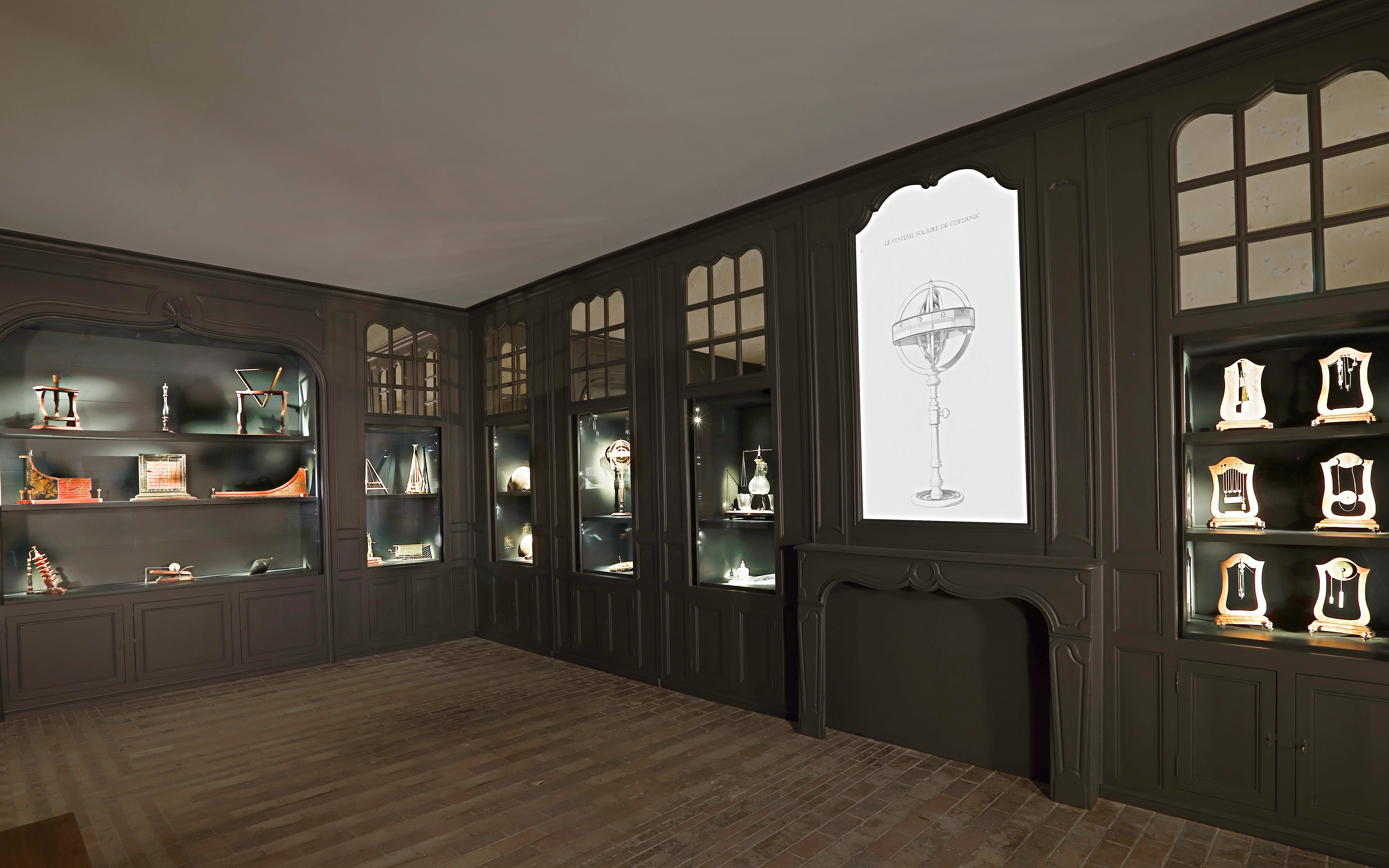 Chenonceau Castle interior with illuminated display of historical instruments.