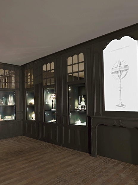 Chenonceau Castle interior with illuminated display of historical instruments.