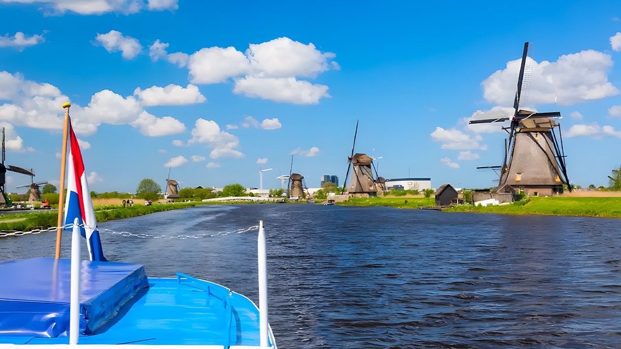 Boat cruise view of windmills along a canal in Keukenhof, Netherlands.