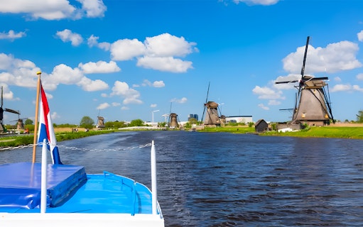 Boat cruise view of windmills along a canal in Keukenhof, Netherlands.