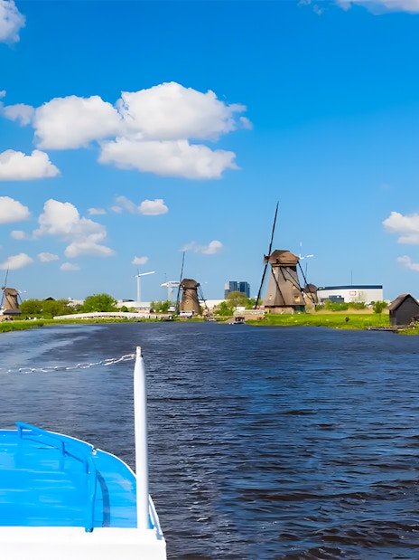 Boat cruise view of windmills along a canal in Keukenhof, Netherlands.