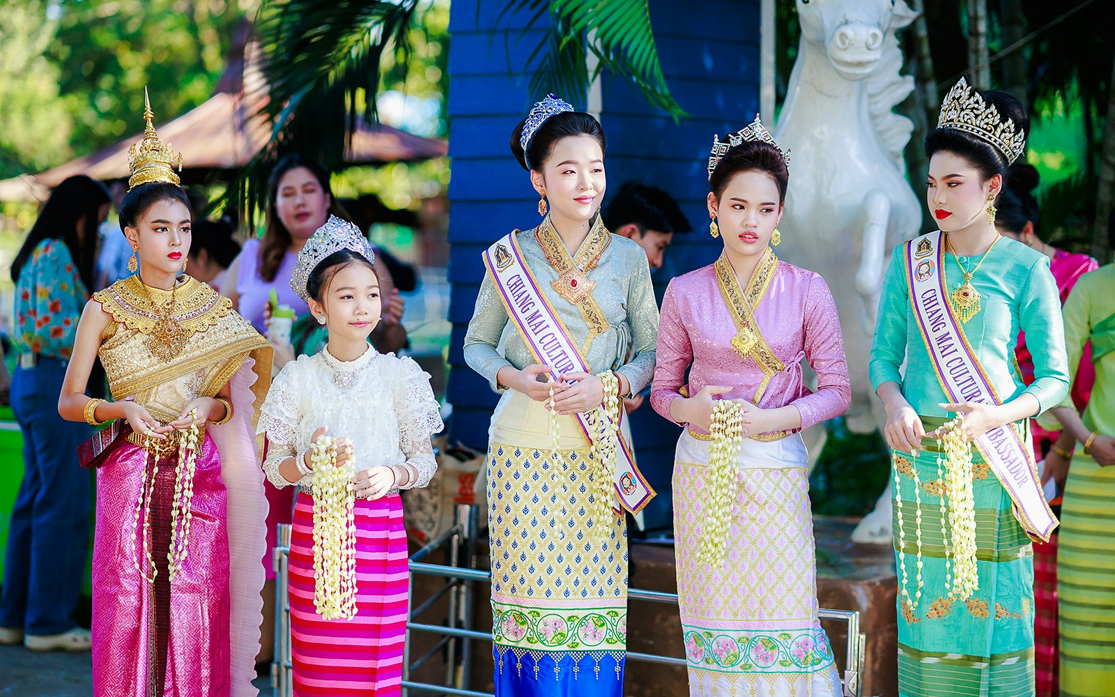 Young women and girls in traditional Thai attire and crowns at Chiang Mai Sky Lanterns Festival.