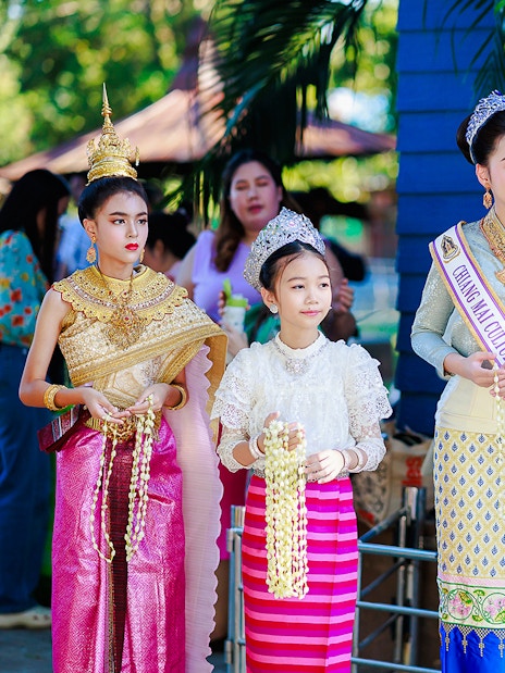 Young women and girls in traditional Thai attire at Chiang Mai Sky Lanterns Festival.