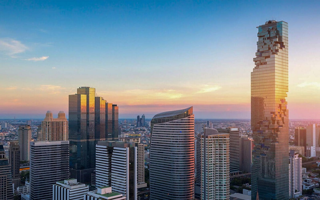 Mahanakhon SkyWalk view of Bangkok skyline at sunset.