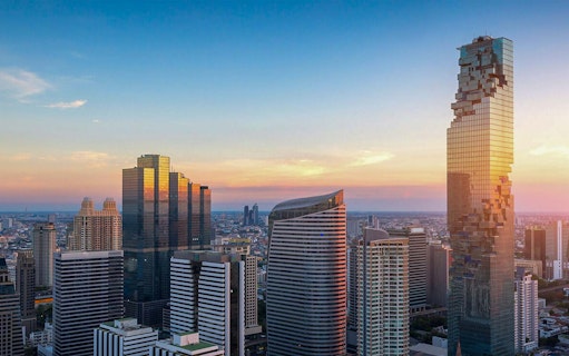 Mahanakhon SkyWalk view of Bangkok skyline at sunset.