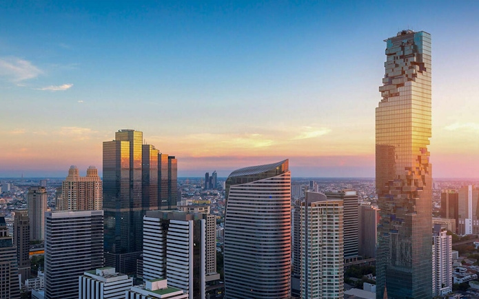 Mahanakhon SkyWalk view of Bangkok skyline at sunset.