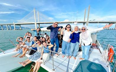 Group enjoying catamaran cruise near Penang Bridge, Penang.