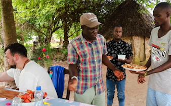 Guests enjoying lunch under trees on Funzi Island during Diani Beach excursion.