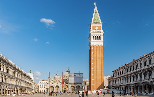 St. Mark's Bell Tower in Venice with tourists in the square.