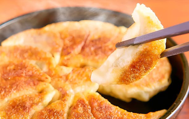Gyoza dumpling being picked up with chopsticks at Hakata Dojo Yaesu.