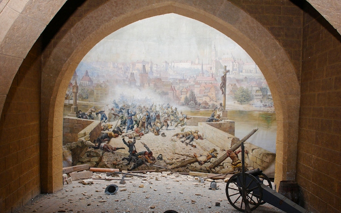 Historical battle scene mural inside Mirror Maze, depicting soldiers on a bridge with a city backdrop.