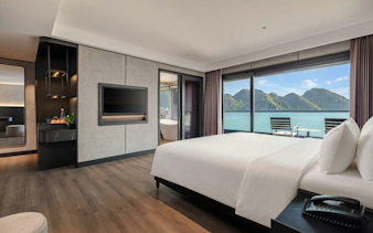 Luxury hotel room with ocean view in Ha Long Bay, featuring modern decor and large windows.
